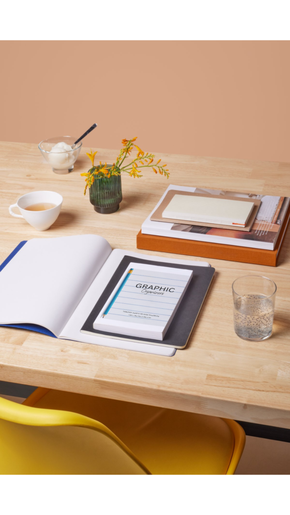 A desk with an open notebook and a close book titled 'graphic organizer'
